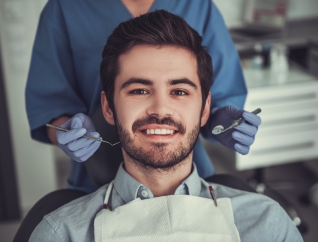 Man with short beard smiling in dental chair