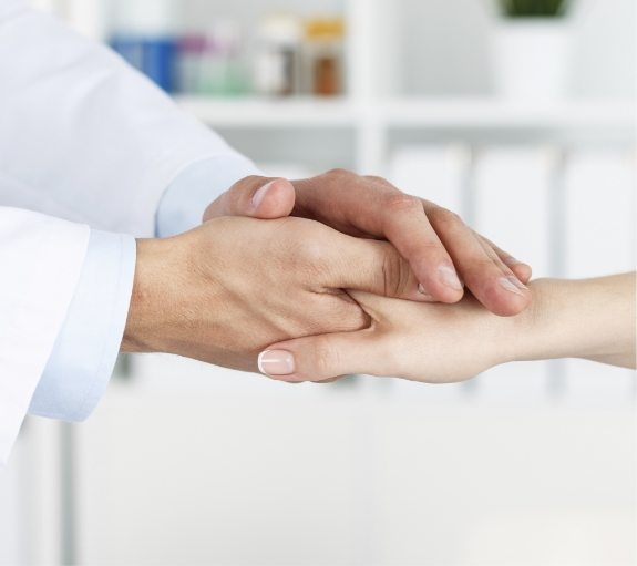 Close up of one person holding another persons hand in both of theirs