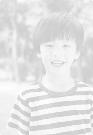 Child in striped shirt smiling outdoors
