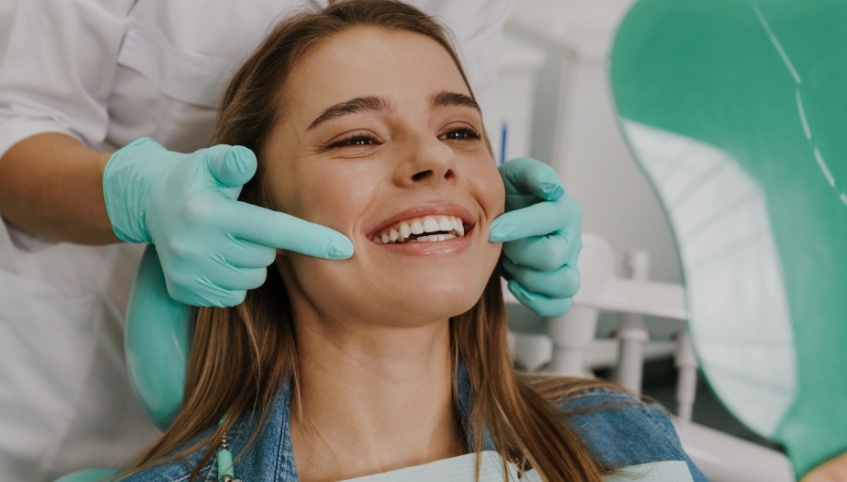 Young woman smiling while visiting her dentist in Topsham