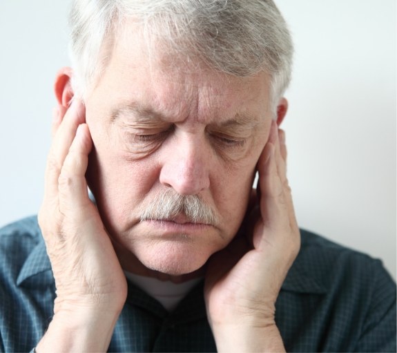 Man touching his temples in pain