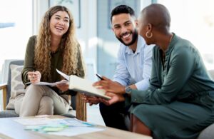 3 people smiling and working together